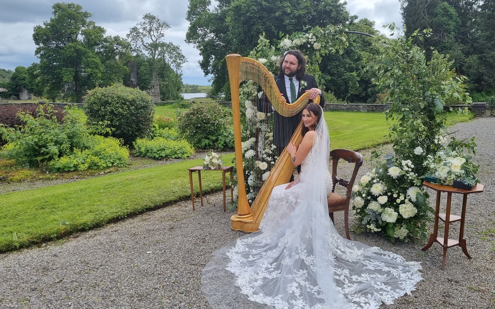Bride playing the harp in the gardens at Temple House